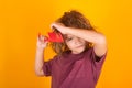 Closeup portrait of little child brushing hair isolated on yellow studio background. Cute child with comb. Blonde kid Royalty Free Stock Photo