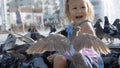 Closeup portrait of little cute girl feeding street pigeons in the park Royalty Free Stock Photo