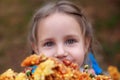 Closeup portrait of little girl with big beautiful eyes and with bouquet of wildflowers. Girl with bouquet of daisies. Kid with bo