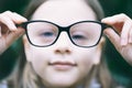 Closeup portrait of little girl with myopia correction glasses.