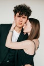 Closeup portrait of loving couple in black outfits for event, gray studio background. Handsome guy and elegant girl Royalty Free Stock Photo