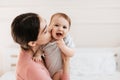 Closeup portrait of loving young mom kissing little kid in cheek, bonding with her adorable son or daughter, free space Royalty Free Stock Photo