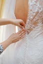 Closeup portrait of a maid of honor helping the bride with her dress Royalty Free Stock Photo