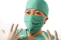 Closeup portrait of mature attractive and happy medicine doctor woman or hospital nurse in medical scrubs latex gloves and mask Royalty Free Stock Photo