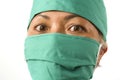 Closeup portrait of mature attractive medicine doctor woman or hospital nurse in medical scrubs and mask looking intense to camera