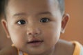 Closeup portrait of a 10 month old baby laying down looking at the camera with beautiful eyes