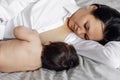 Closeup portrait of mother breastfeeding with love her little daughter in bedroom, gray background. Baby suckle milk and Royalty Free Stock Photo