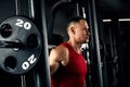 Closeup portrait of a muscular man workout with barbell at gym. Brutal bodybuilder athletic man with six pack, perfect Royalty Free Stock Photo