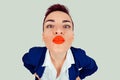 Closeup portrait of nerdy young funny distorted woman face with big red lips trying to blow a kiss to you camera, isolated light Royalty Free Stock Photo