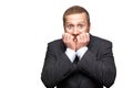 Closeup portrait of nervous handsome businessman with facial beard in black suit standing, biting his nails and looking at camera Royalty Free Stock Photo