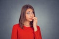 Nervous looking woman biting her fingernails craving something Royalty Free Stock Photo