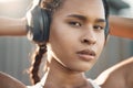 Closeup portrait of one fit young hispanic woman listening to music with headphones while exercising in an urban setting Royalty Free Stock Photo