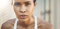 Closeup portrait of one fit young hispanic woman taking a rest break to catch her breath after a run or jog in an urban