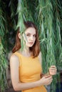 Closeup portrait of pensive sad beautiful young Caucasian woman girl in yellow dress with red hair, brown eyes, looking in camera Royalty Free Stock Photo