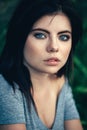 Closeup portrait of pensive thoughtful beautiful young Caucasian woman with black hair, blue eyes, looking in camera Royalty Free Stock Photo