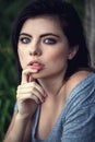 Closeup portrait of pensive thoughtful beautiful young Caucasian woman with black hair, blue eyes, looking in camera Royalty Free Stock Photo