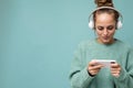 Closeup portrait photo of beautiful positive young woman wearing blue sweater isolated over blue background wearing