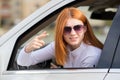 Closeup portrait of pissed off displeased angry aggressive woman driving a car shouting at someone with finger to temple gesture