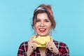 Closeup portrait of a positive beautiful young woman wearing a plaid shirt taking pictures with a yellow vintage camera Royalty Free Stock Photo