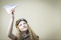 Closeup portrait of Positive Caucasian Teenage Girl in Flying Glasses Launching Origami Paper Plane Over Beige Background Royalty Free Stock Photo