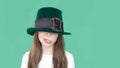 A closeup portrait of preteen girl in St. Patrick& x27;s Day hat on green backgroundwhite. Copy space Royalty Free Stock Photo