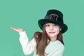 A closeup portrait of preteen girl in St. Patrick& x27;s Day hat on green backgroundwhite. Copy space Royalty Free Stock Photo