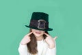 A closeup portrait of preteen girl in St. Patrick& x27;s Day hat on green backgroundwhite. Copy space Royalty Free Stock Photo