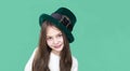 A closeup portrait of preteen girl in St. Patrick& x27;s Day hat on green backgroundwhite. Copy space Royalty Free Stock Photo