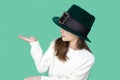 A closeup portrait of preteen girl in St. Patrick& x27;s Day hat on green backgroundwhite. Copy space Royalty Free Stock Photo