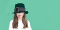 A closeup portrait of preteen girl in St. Patrick& x27;s Day hat on green backgroundwhite. Copy space Royalty Free Stock Photo