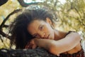 Closeup portrait of a pretty Afro-Columbian woman leaning on a stone surface outdoors in a park