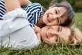 Closeup portrait of pretty woman playing with her cute little girl on green grass outdoor. Loving pretty daughter smiling and Royalty Free Stock Photo