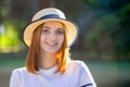 Closeup portrait of redhead hipster teenage girl in yellow hat smiling outdoors in sunny summer park Royalty Free Stock Photo