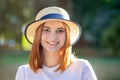 Closeup portrait of redhead hipster teenage girl in yellow hat smiling outdoors in sunny summer park Royalty Free Stock Photo