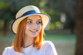 Closeup portrait of redhead hipster teenage girl in yellow hat smiling outdoors in sunny summer park Royalty Free Stock Photo