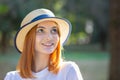 Closeup portrait of redhead hipster teenage girl in yellow hat smiling outdoors in sunny summer park Royalty Free Stock Photo