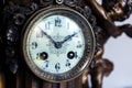 A closeup portrait of the retro clock face of an old vintage clock made of wood and metal with beautiful clock hands and numbers