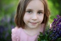 Closeup portrait of a romantic charming little girl with long hair. Childhood concept. Smiling child girl with big eyes looking in