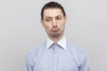 Closeup portrait of sad dissatisfied handsome bristle businessman in classic light blue shirt standing and looking away with pout Royalty Free Stock Photo