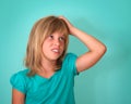 Closeup portrait of sad, stressed, thoughtful little girl, full of worries, looking to the side, isolated on turquoise background.