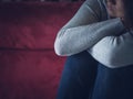 Closeup portrait of sad young woman sitting by sofa at home. Royalty Free Stock Photo