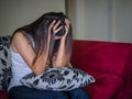 Closeup portrait of sad young woman sitting by sofa at home. Royalty Free Stock Photo