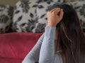 Closeup portrait of sad young woman sitting by sofa at home. Royalty Free Stock Photo