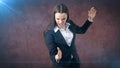 Closeup portrait screaming business woman raising hands in the air attack with kung foo chop.