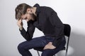 Closeup portrait of a seated anxious bearded young man over white background