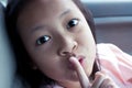 Closeup portrait secretive asian child girl placing finger keep quiet gesture