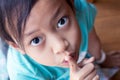Closeup portrait secretive asian child girl placing finger keep quiet gesture
