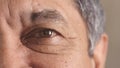 Closeup portrait of a senior mans eye at the optometrist. Side of a retired males face with zoom on his eyeball and lens