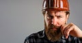 Closeup portrait of serious construction worker in hard hat. Bearded workman in plaid shirt and protective helmet. Male Royalty Free Stock Photo