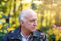 Closeup portrait of an serious elegant senior man thinking about something at the garden Royalty Free Stock Photo